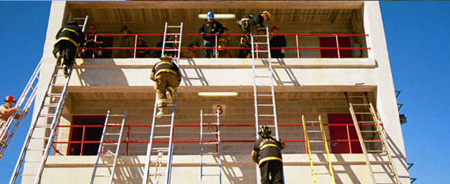 Picture of firefighters climbing ladders to climb a building